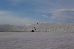 People sliding down sand dune